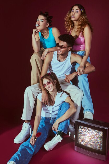 Portrait of young friends in 2000s fashion style posing with television