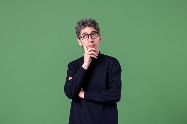 緑の壁に撮影されたスタジオでカジュアルな服を着た若い天才男の肖像画
