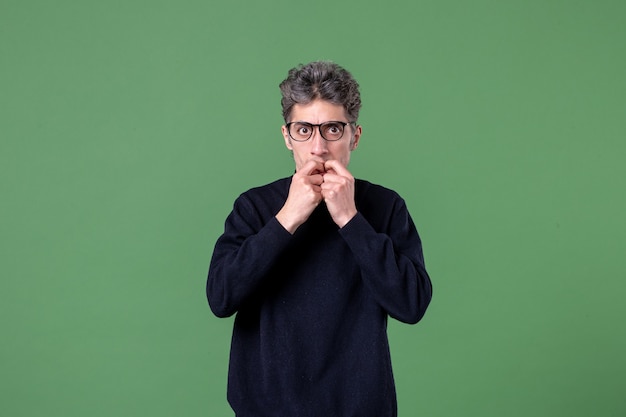 Portrait of young genius man dressed casually in studio shot on green wall