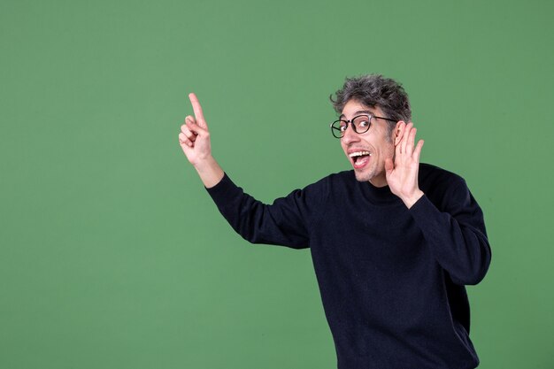 Portrait of young genius man dressed casually in studio shot on green wall