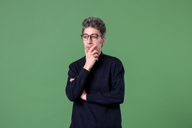 Portrait of young genius man dressed casually in studio shot on green wall