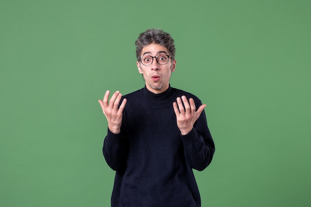 Foto gratuita ritratto di giovane genio vestito casualmente in studio girato su parete verde