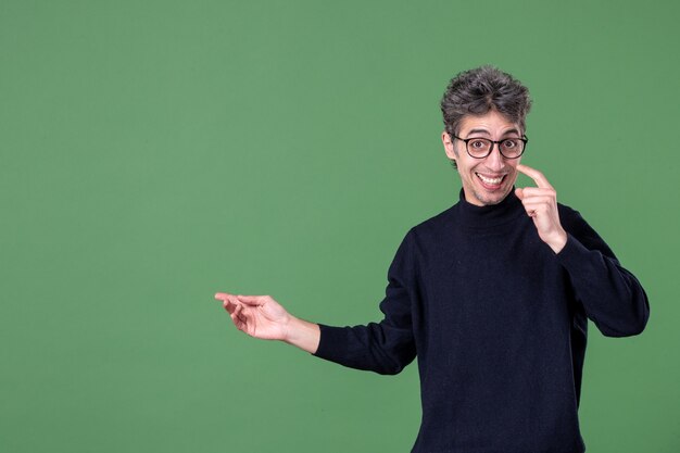 Portrait of young genius man dressed casually in studio shot pleased on green wall