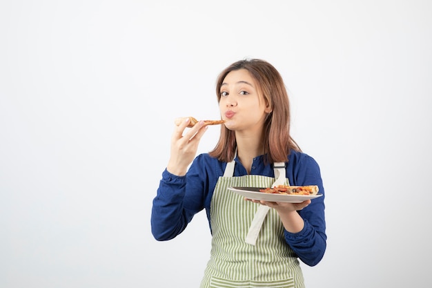 白でピザを食べるエプロンの少女の肖像画