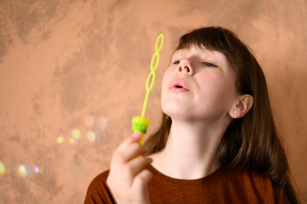 Portrait of young girl blowing bubbles