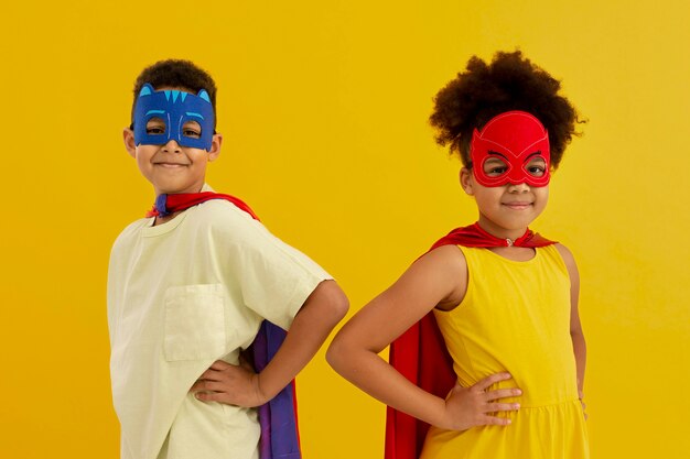 Portrait of young girl and boy with superhero capes