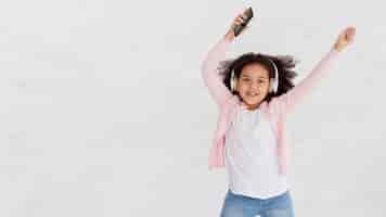 Free photo portrait of young girl dancing at home
