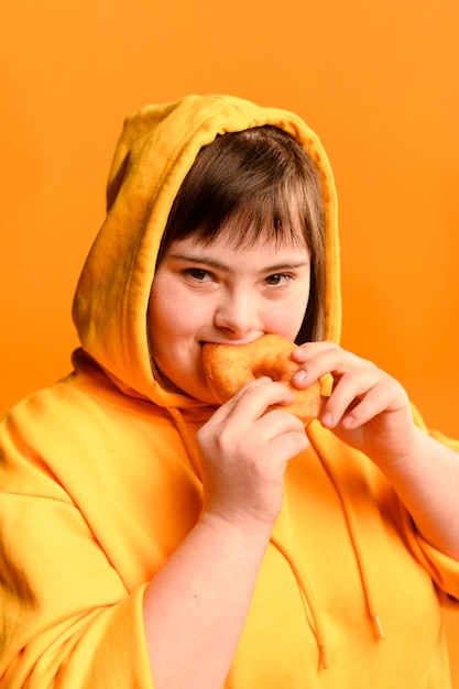Портрет молодой девушки едят пончик