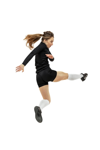 Portrait of young girl football player in motion training isolated over white studio background Scoring a goal