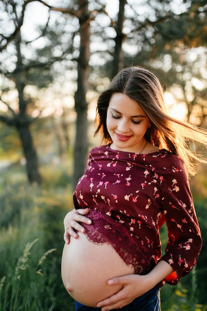 Foto gratuita il ritratto della ragazza su erba e gli alberi parcheggiano il paesaggio