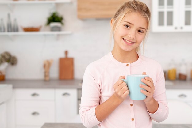 Portrait of young girl holding a mug