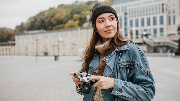 Portrait of a young girl holding a professional camera