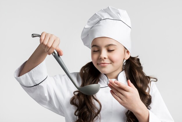 Portrait of young girl holding soup ladle