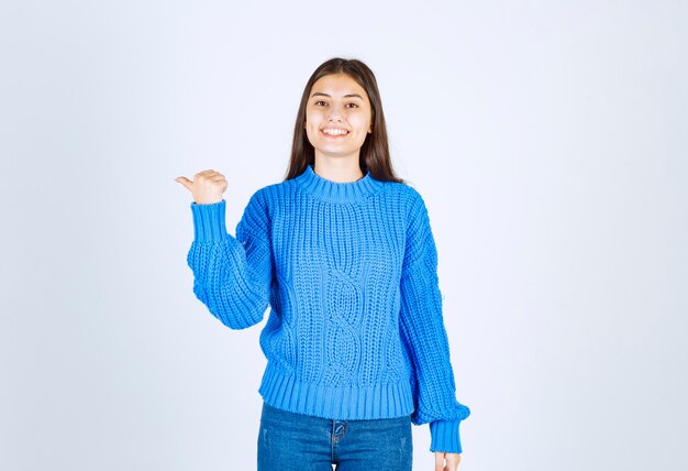 Portrait of a young girl model standing with crossed hands and looking away.