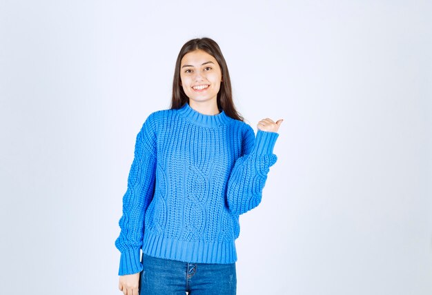 Portrait of a young girl model standing with crossed hands and looking away.