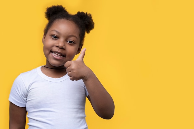 Free photo portrait of young girl showing thumbs up