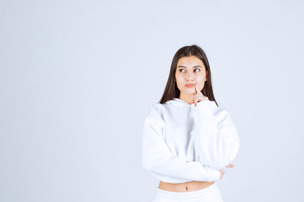 Portrait of a young girl standing and looking away .