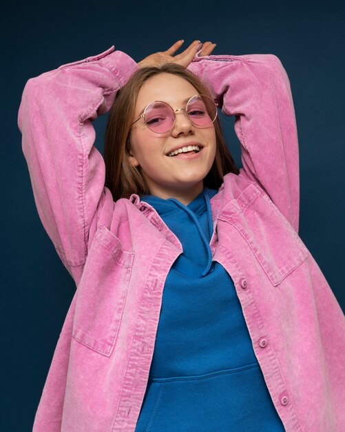 Портрет молодой девушки в солнцезащитных очках, выглядящей расслабленной