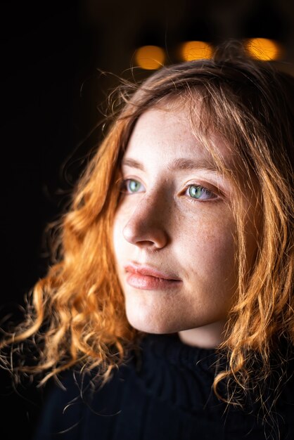 Portrait of young girl with ginger hair, green eyes and freckles.