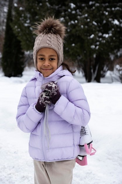 Foto gratuita ritratto di giovane ragazza con pattini da ghiaccio all'aperto in inverno