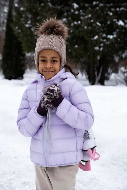 Портрет молодой девушки с коньками на открытом воздухе зимой