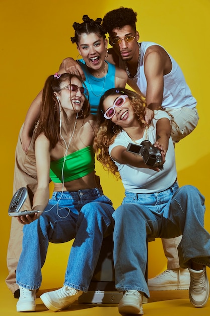 Портрет молодой группы друзей в стиле моды 2000-х, позирующих с камерой