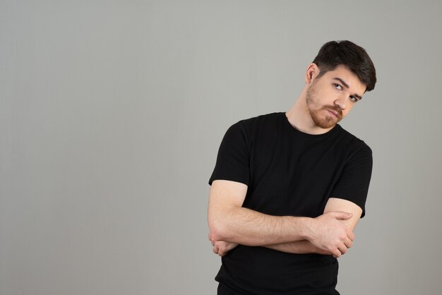 Portrait of young guy crossing his arms and looking at camera.