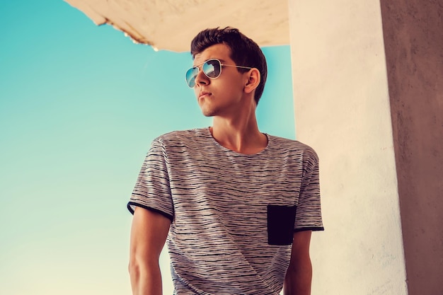 Free photo portrait of young guy in sunglasses. over blue background