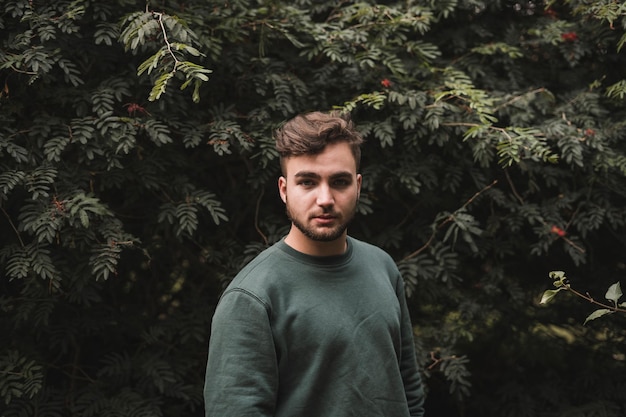 Portrait of a young handsome Caucasian man in a park