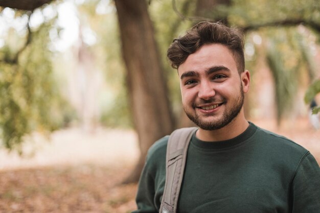 Portrait of a young handsome cute Caucasian man in a park