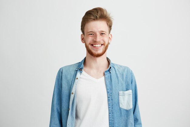 Portrait of young handsome hipster man with beard smiling laughing.