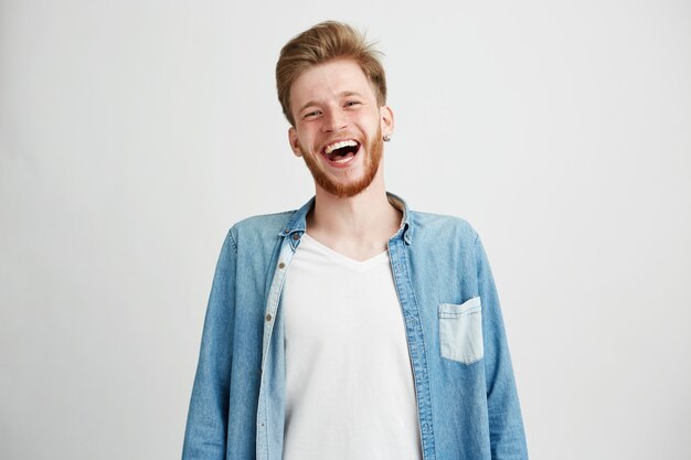 Portrait of young handsome hipster man with beard smiling laughing.