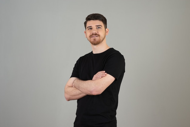 Portrait of young handsome man crossed his arms and looking at camera.