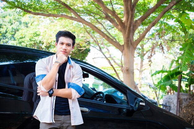 Portrait young handsome man posed standing with car