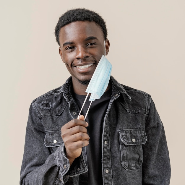 Free photo portrait young handsome man posing with mask