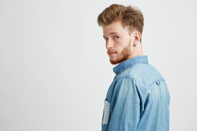 Portrait of young handsome man smiling looking turning to camera.