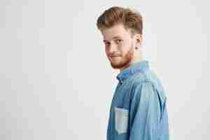 Free photo portrait of young handsome man smiling looking turning to camera.