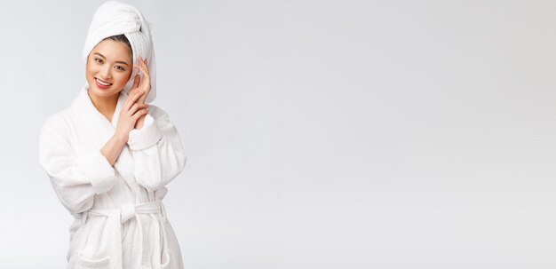 Portrait of a young happy asian lady in bathrobeIsolated in white background