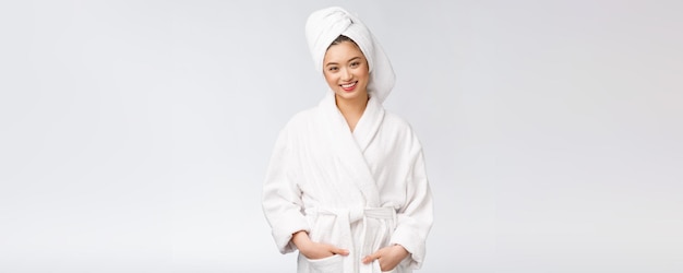 Портрет молодой счастливой азиатки в халате, изолированном на белом фоне