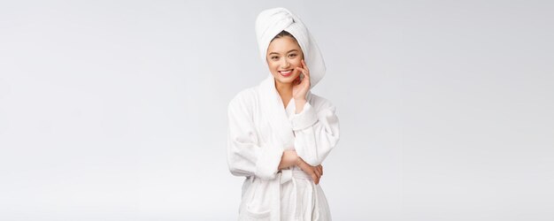 Portrait of a young happy asian lady in bathrobeIsolated in white background