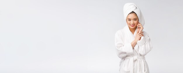 Portrait of a young happy asian lady in bathrobeIsolated in white background