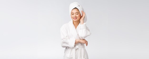 Portrait of a young happy asian lady in bathrobeIsolated in white background