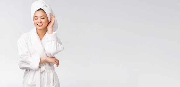 Portrait of a young happy asian lady in bathrobeIsolated in white background