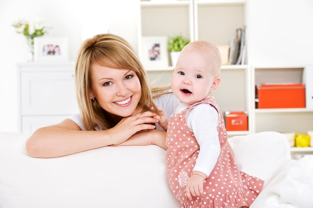 Free photo portrait of young happy mother with newborn baby at home