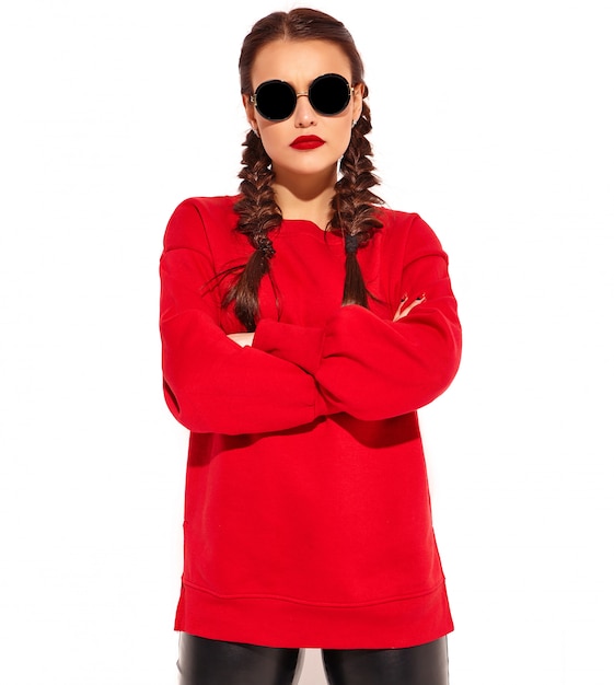 Portrait of young happy smiling woman model with bright makeup and colorful lips with two pigtails and sunglasses in summer red clothes isolated. Сrossed arms