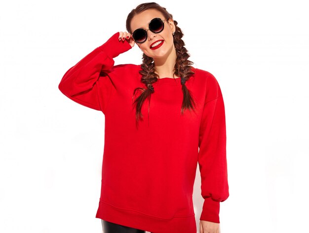 Portrait of young happy smiling woman model with bright makeup and colorful lips with two pigtails and sunglasses in summer red clothes isolated. 