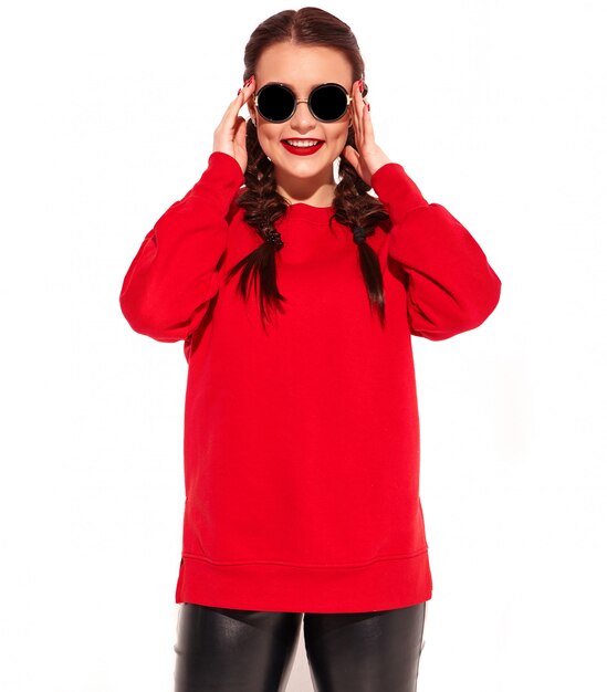 Portrait of young happy smiling woman model with bright makeup and colorful lips with two pigtails and sunglasses in summer red clothes isolated. 