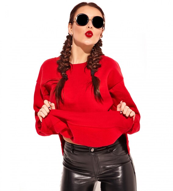 Portrait of young happy smiling woman model with bright makeup and colorful lips with two pigtails and sunglasses in summer red clothes isolated. 