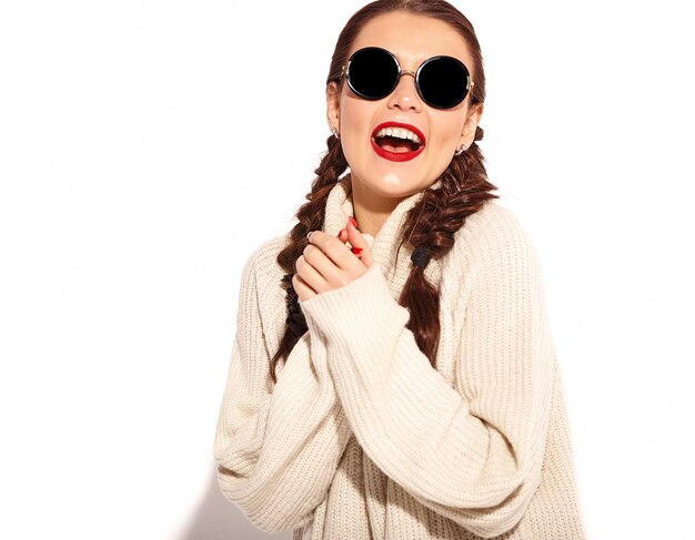 Portrait of young happy smiling woman model with bright makeup and red lips with two pigtails in summer warm sweater clothes isolated. 