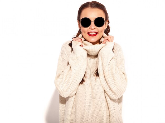 Portrait of young happy smiling woman model with bright makeup and red lips with two pigtails in summer warm sweater clothes isolated. 